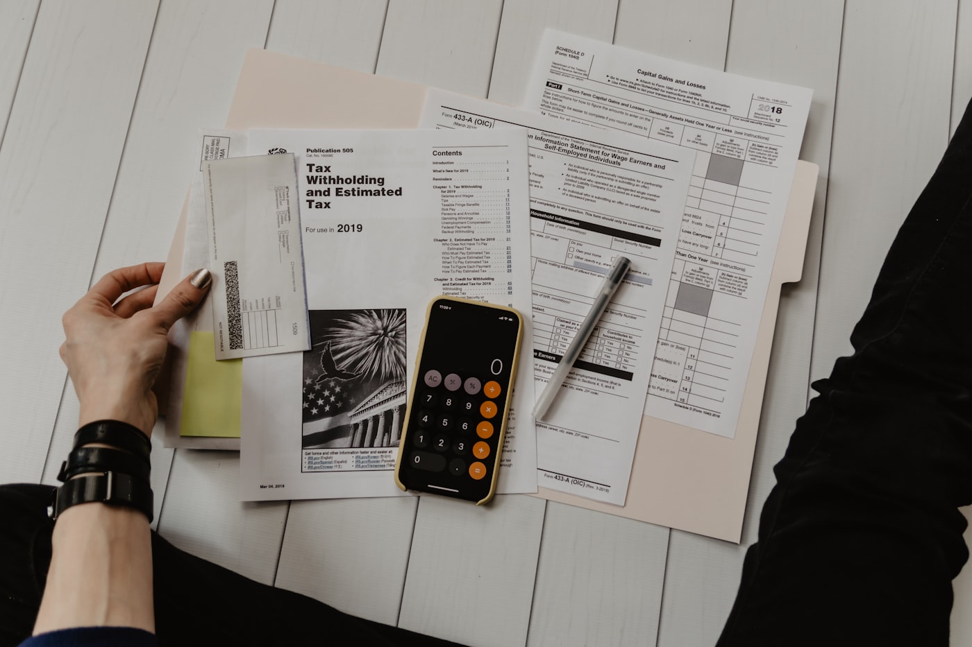 Auditor reviewing financial statements with a calculator